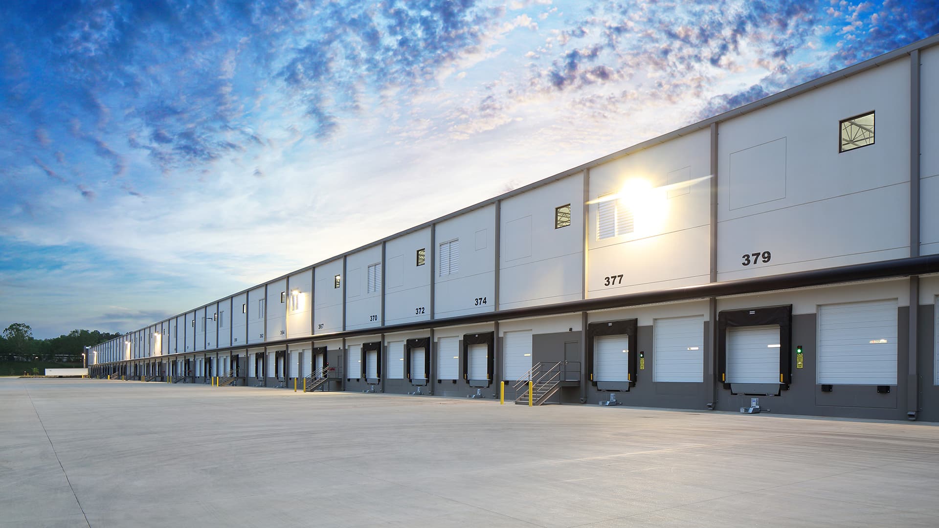 Exterior Of Modern Distribution Center Warehouse At Sunrise