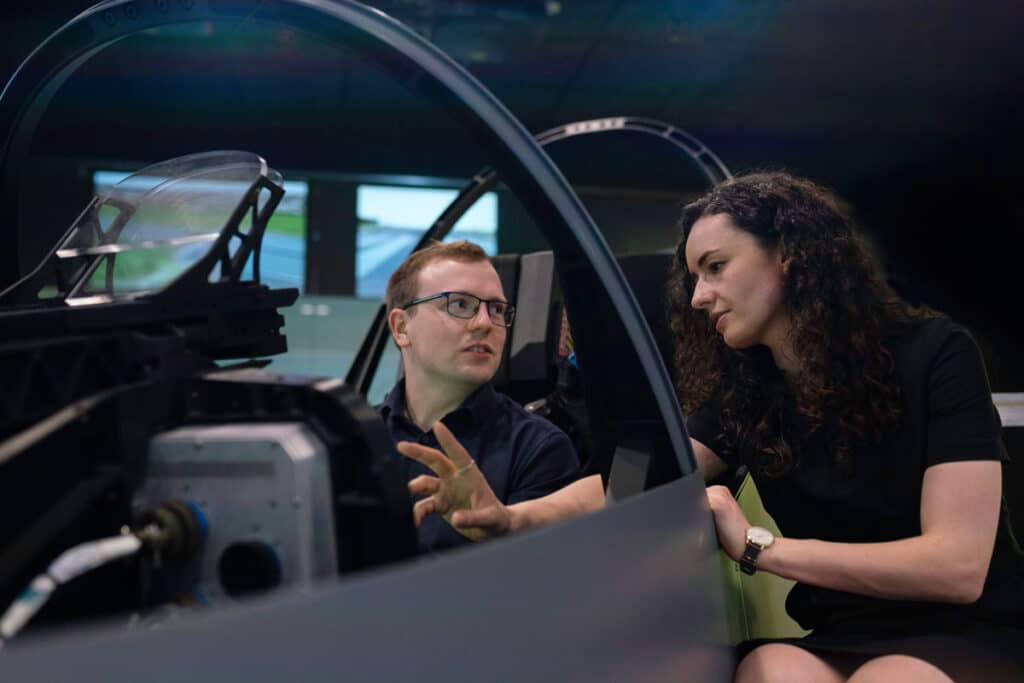 Two People Sitting In A Display Jet