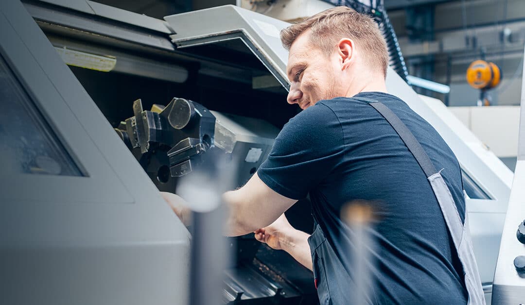 Man Operating A Cnc Machine In A Facility
